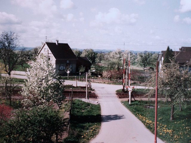 Ältere Aufnahme eines Bahnüberganges mit Haus im Hintergrund